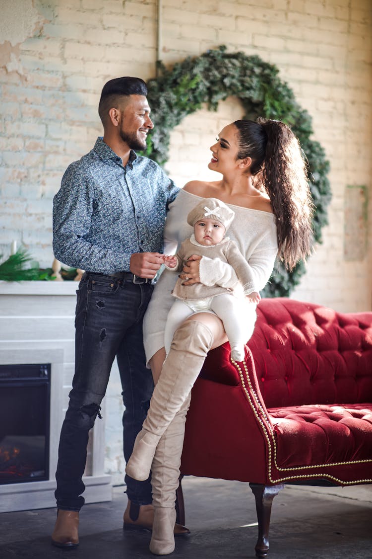 Couple Looking At Each Other Carrying A Baby