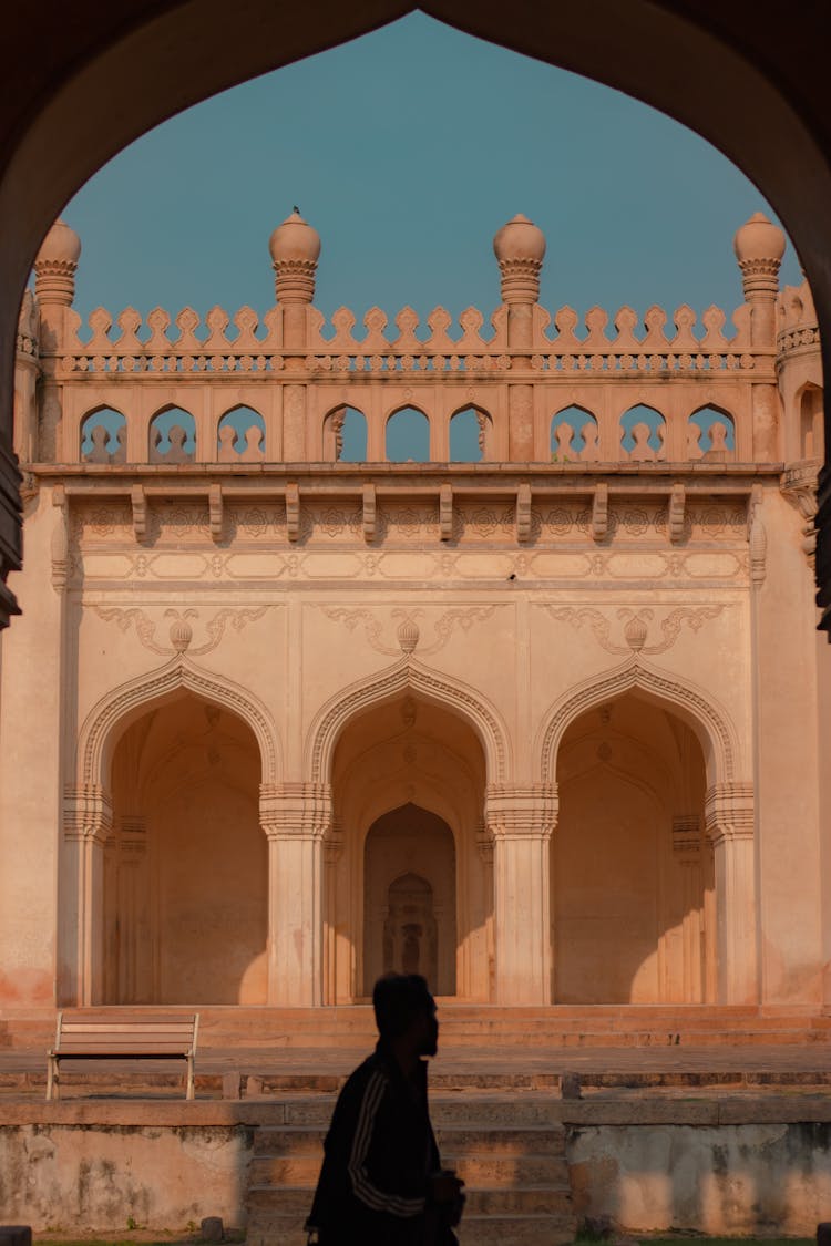 Man Walking Near Building Courtyard