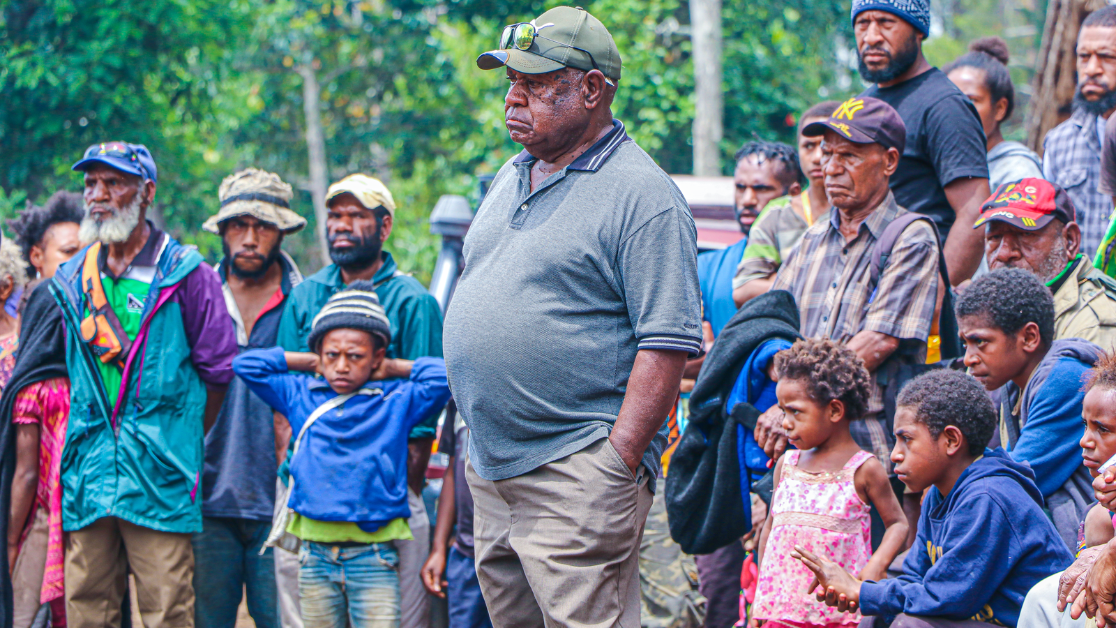 Man in gray polo shirt standing in front of children, Equatorial Guinea