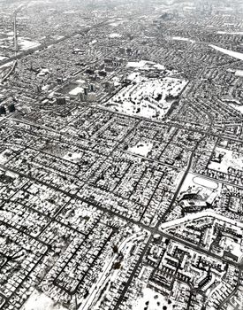 Aerial view of a city covered in snow, showcasing urban planning and winter scenery.