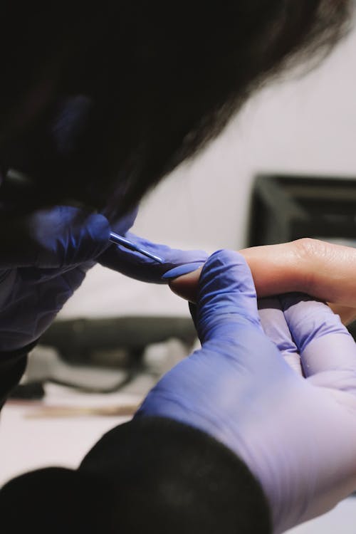 A Person Painting the Nail of a Client