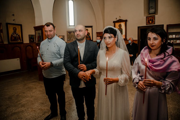 People At A Wedding Holding Candles