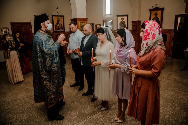 Priest Blessing People In Church