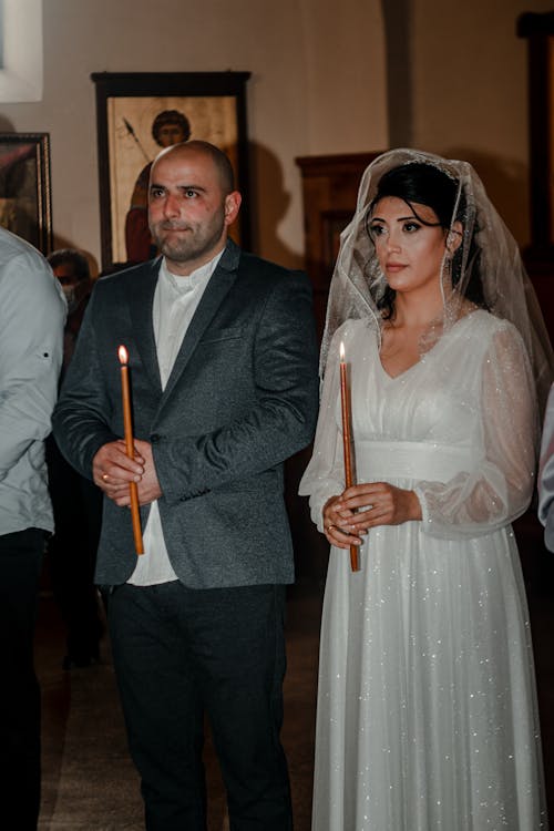 Man and Woman Holding Candles at Their Wedding