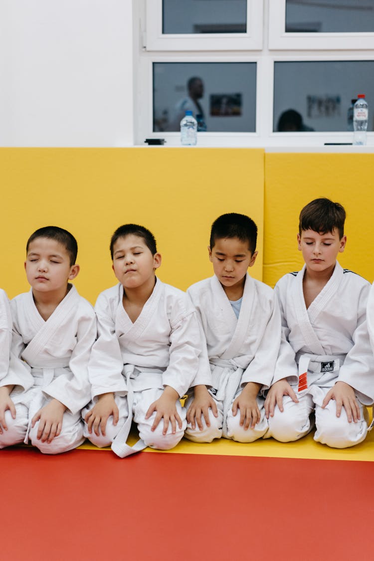 Group Of Boys Kneeling In Meditation Before Karate Training