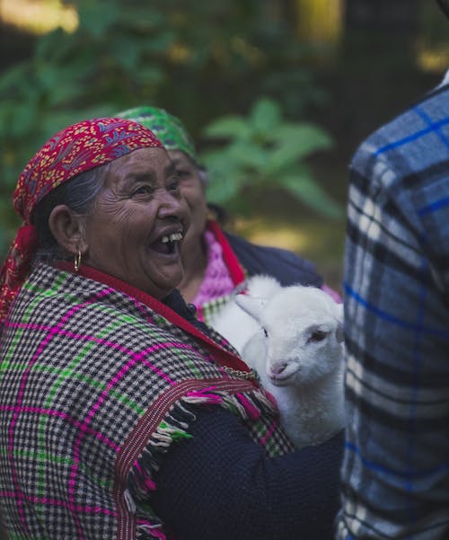 Woman with Red Bandana Holding a Sheep with a Big Smile