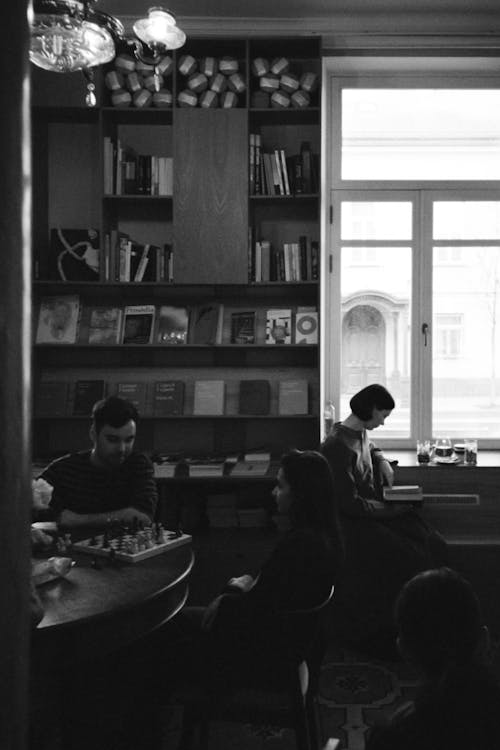 Grayscale Photo of a Man and a Woman Playing Chess