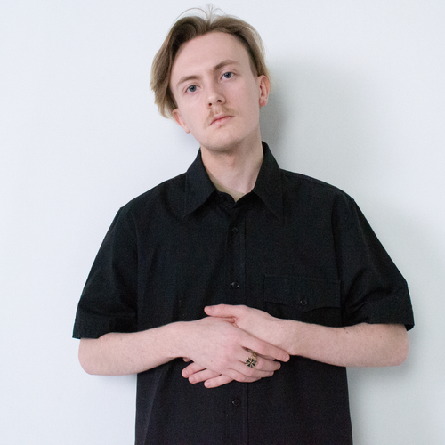 Free A young man posing in a black shirt, standing against a white background. Stock Photo