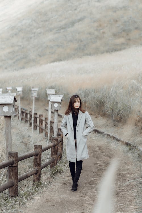 Woman in Gray Coat Walking on Path