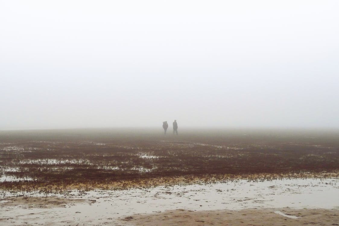 Dos Personas Caminando Sobre El Campo Cubierto De Niebla