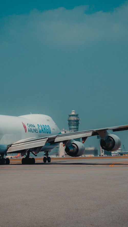 Free A cargo airplane on the tarmac near an airport control tower, ready for takeoff. Stock Photo