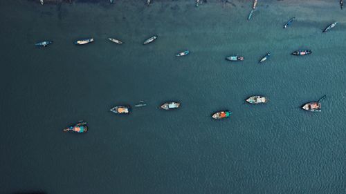 Free Drone shot of scattered boats floating on a tranquil blue sea. Stock Photo