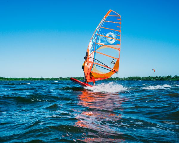 Windsurfer gliding across blue water