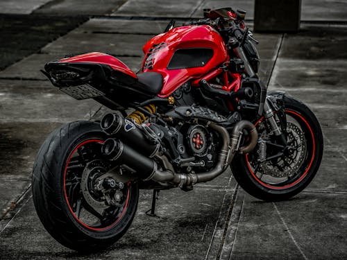 Red and Black Sports Bike Parked on Gray Concrete Pavement