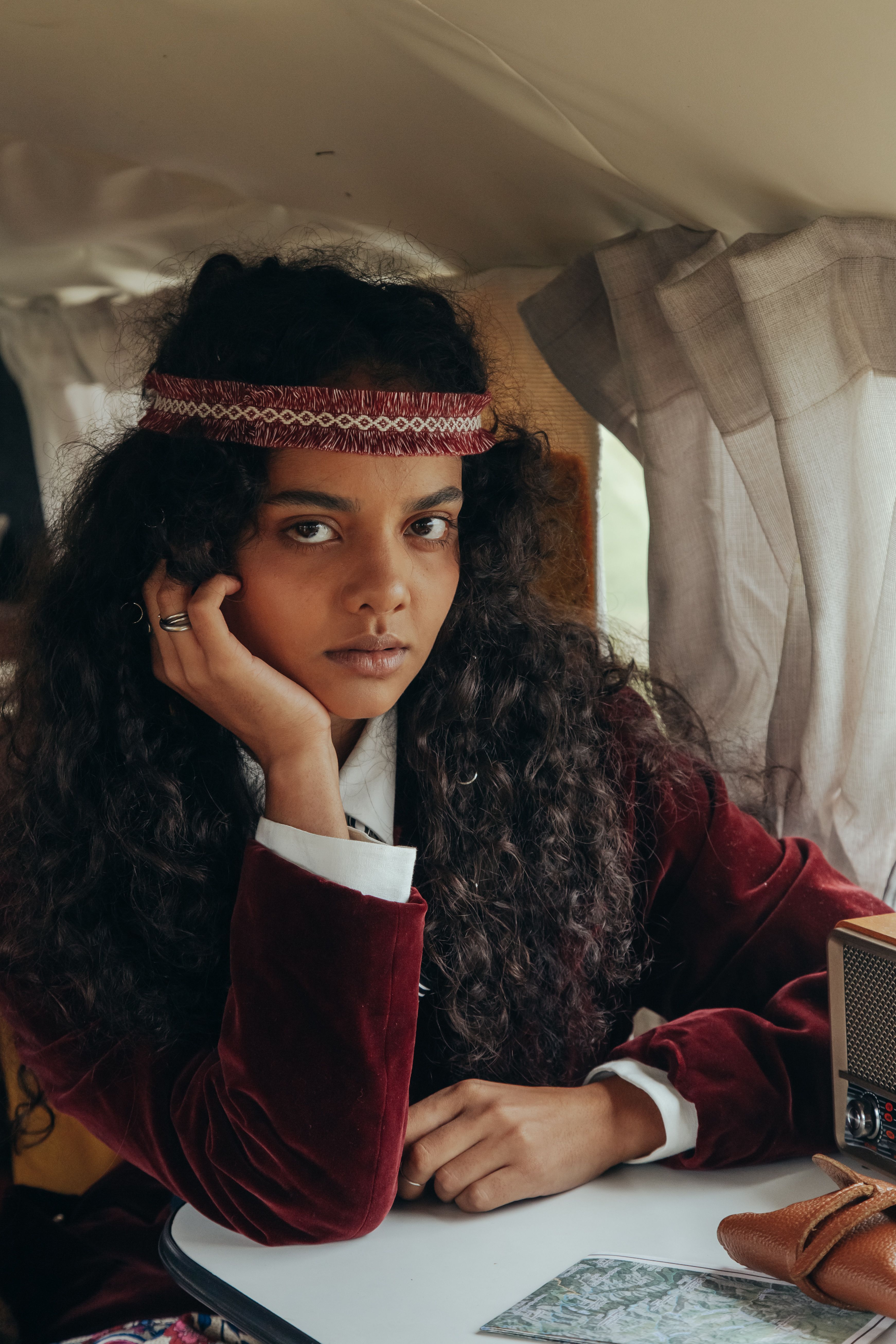 Vintage style portrait of a woman sitting inside a van, showcasing retro fashion.