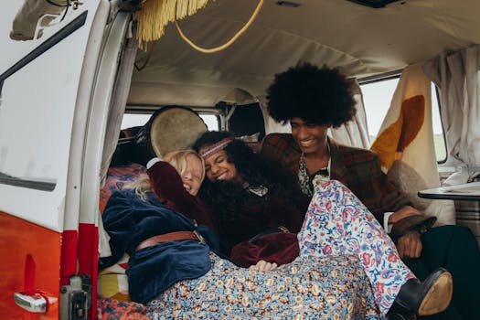 Three friends embrace and smile in a cozy vintage van, exuding a hippie vibe.