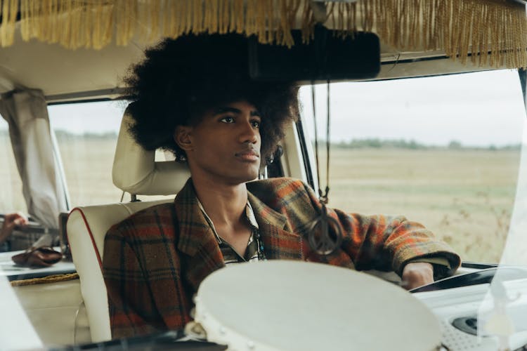 A Man With An Afro Hair Driving A Van