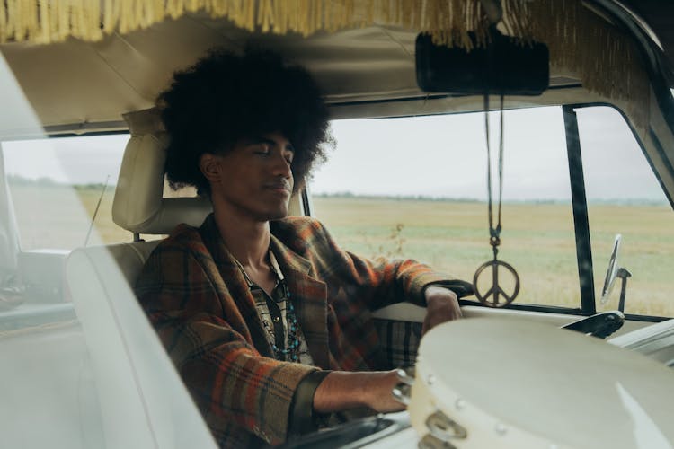 A Man With Afro Hair Driving A Vehicle