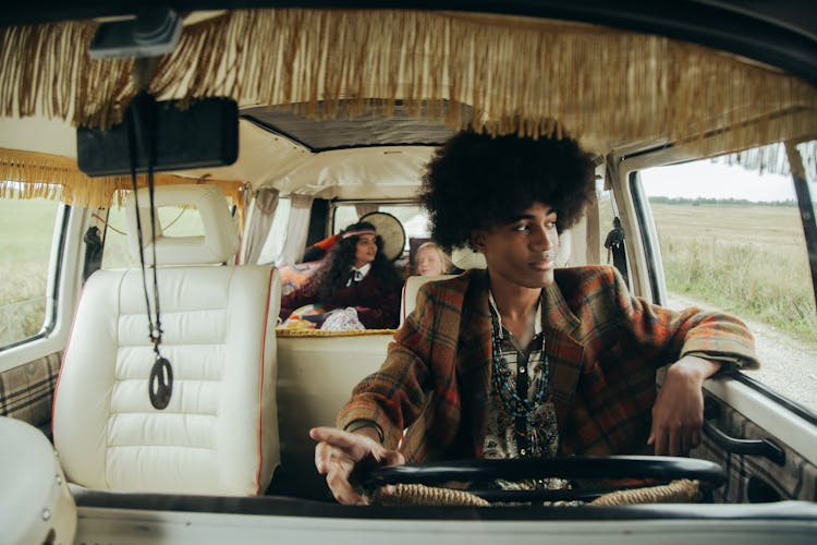 A Man With Afro Hair Driving A Van