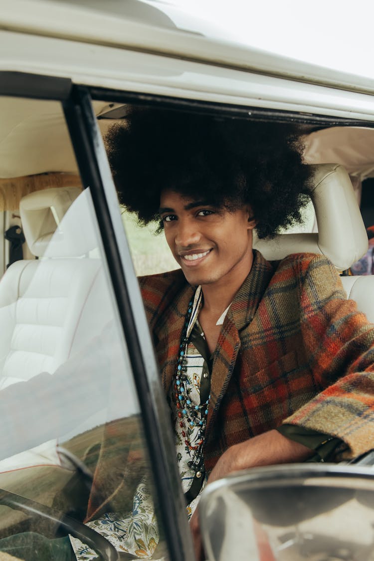 A Man In Plaid Suit Smiling While Sitting Inside The Car