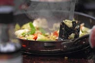 锅中，新鲜蔬菜嘶嘶作响，释放出蒸汽