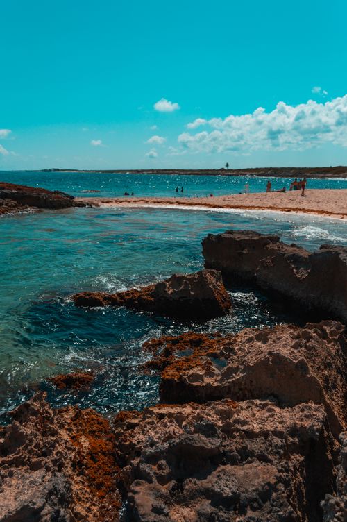 Free Scenic view of a tropical beach with rocks and clear blue ocean in Quintana Roo, Mexico. Stock Photo
