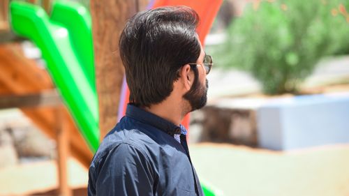 Free Side view of a man with sunglasses enjoying a sunny day in the park. Stock Photo