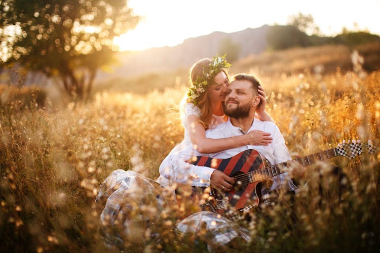 Couple Sitting On A Field