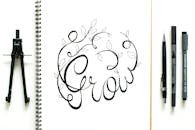 树叶和“成长”文字平铺于艺术作品中，周围环绕着指南针和素描工具