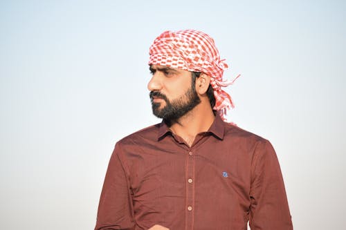 Portrait Photo of Man in Red Button-up Shirt and Red-and-white Headscarf