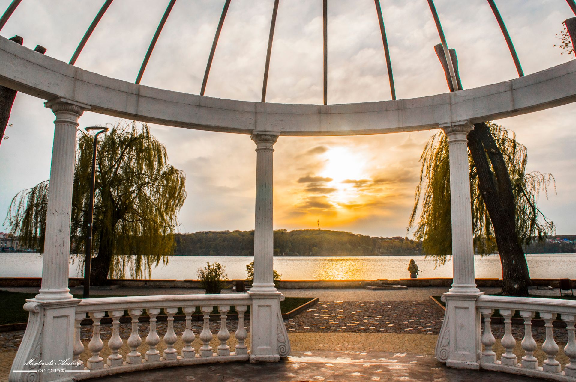Beautiful gazebo framing a serene lake view at sunset, capturing nature's tranquility and architecture's elegance.