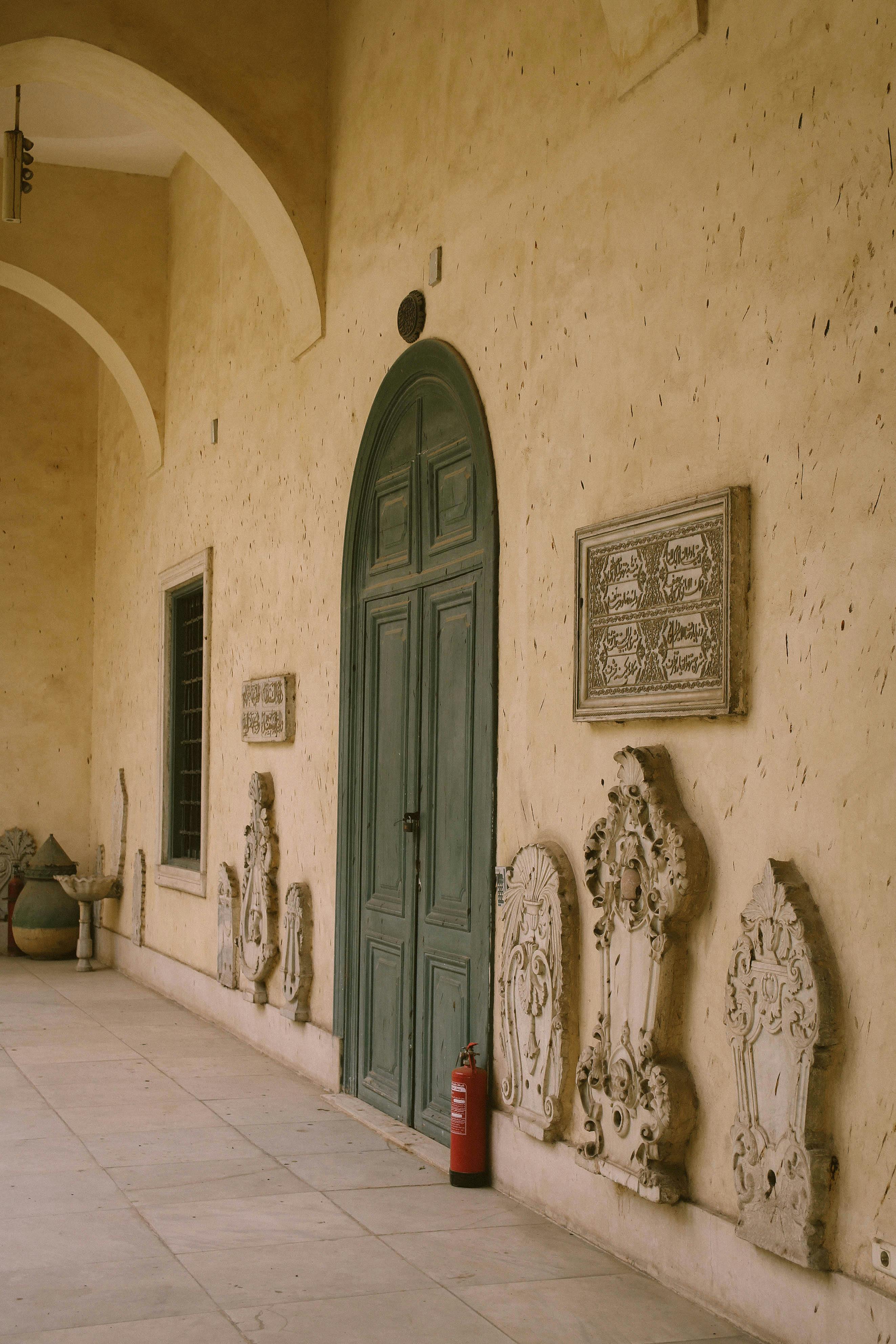 Vintage door with intricate stone reliefs in a historic building corridor, perfect for architecture and art themes.