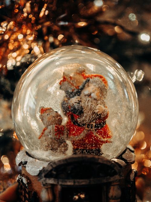 Free Festive Santa Claus snow globe featuring holiday decorations, warm lights, and a cozy atmosphere. Stock Photo