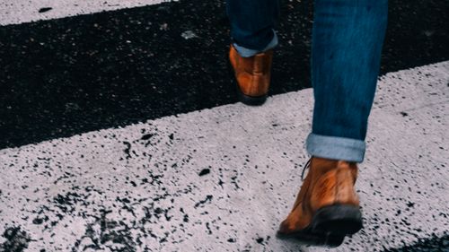 Free Stylish brown boots on a zebra crossing, emphasizing urban lifestyle and walkability. Stock Photo