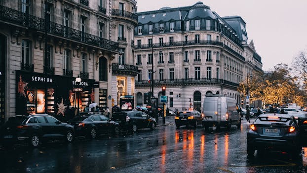 A rainy evening on a busy Paris street with reflections and classic architecture.
