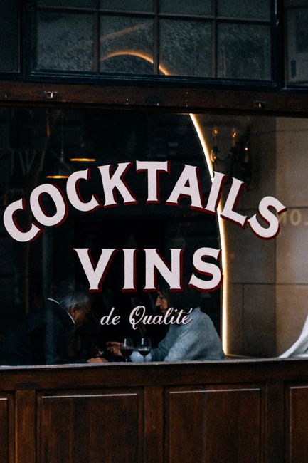A warm cafe scene with vintage signage for cocktails and wines.