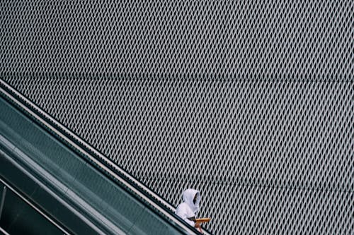 Free Person in a White Hoodie on an Escalator Stock Photo