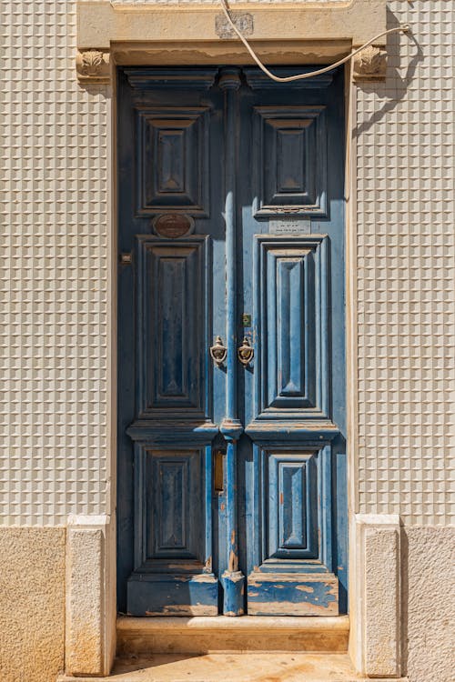 Blue Wooden Door on Brown Brick Wall