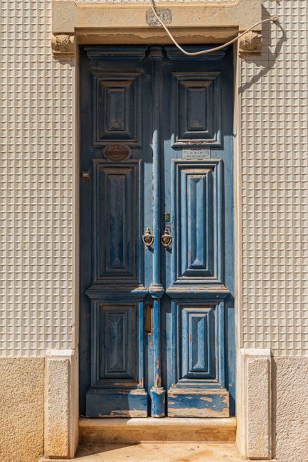 Charming weathered blue door in Silves, Portugal, showcasing rustic design and historic architecture.