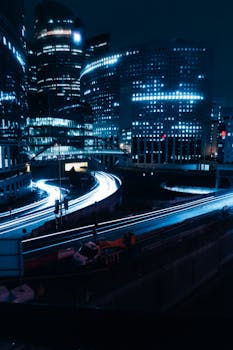 Stunning modern cityscape at night with vibrant light trails showcasing urban life.