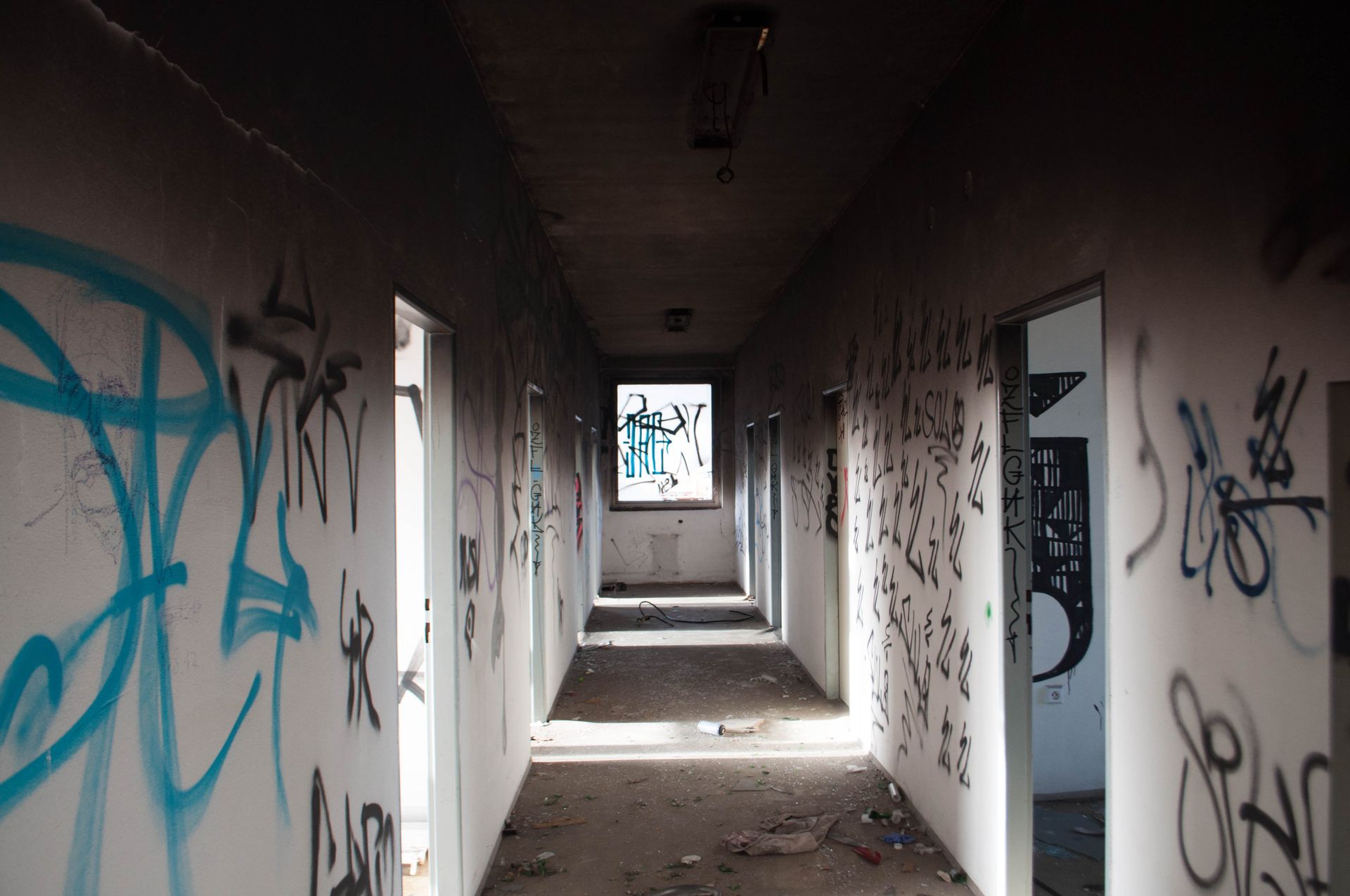 Empty Hallway With Black and Blue Graffiti