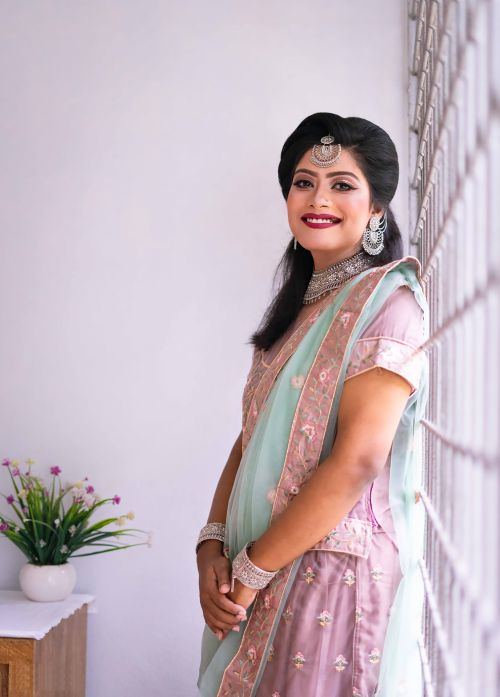 Free Smiling woman in traditional Indian attire with jewelry indoors Stock Photo