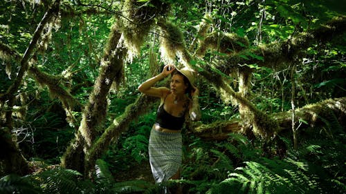 Woman in Black Tank Top and Printed Skirt in the Forest