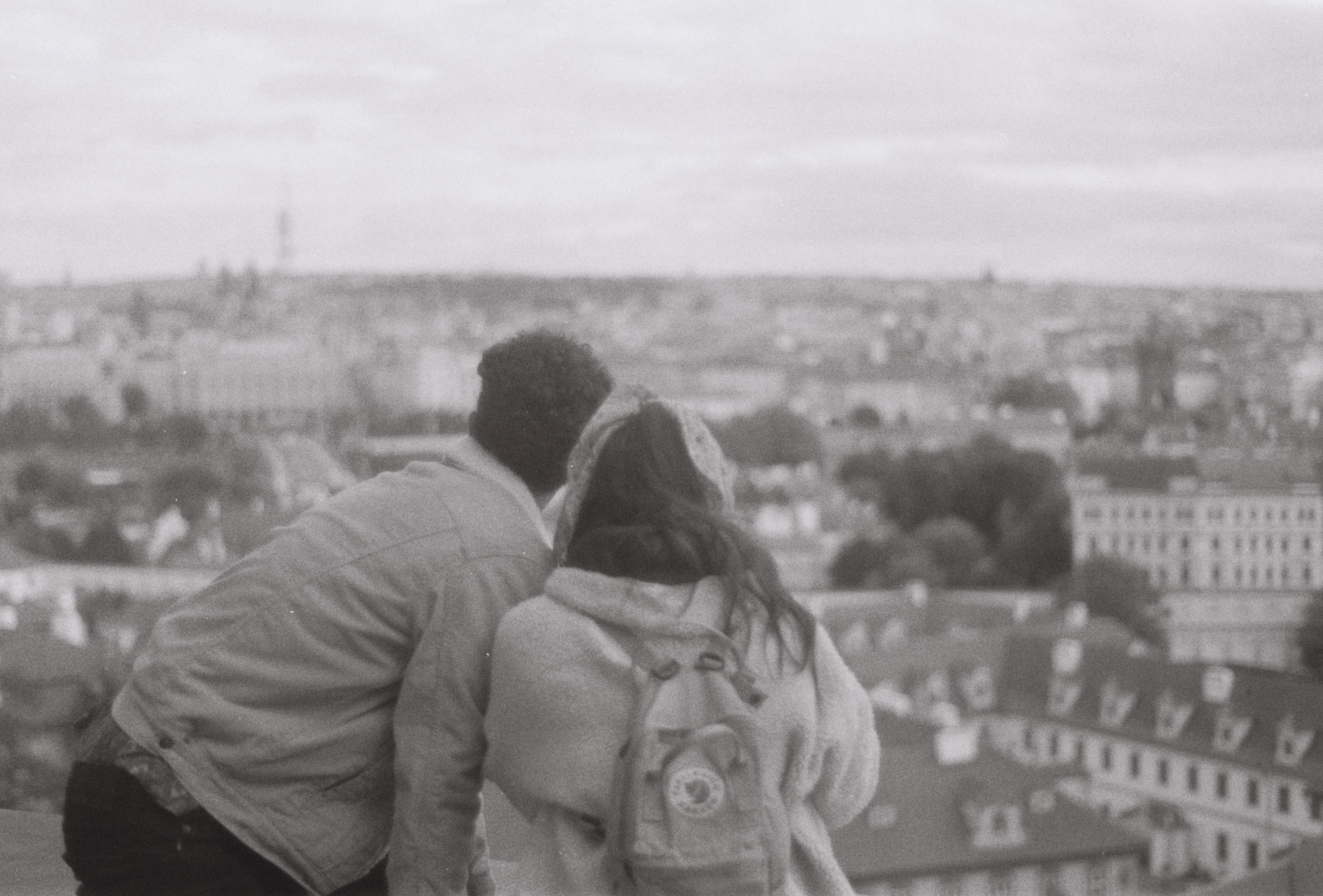Couple enjoys a black and white cityscape view from an elevated point.
