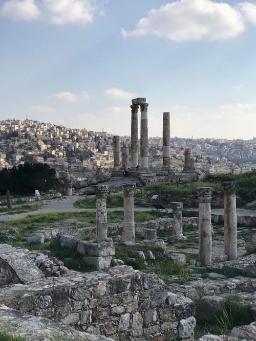 Free View of the ancient Amman Citadel ruins with iconic columns under a blue sky. Stock Photo