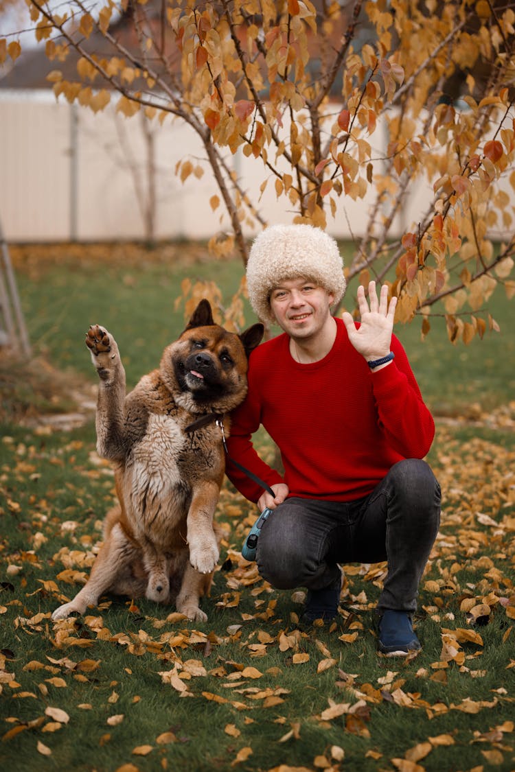 Man Wearing Hat And Dog Waving At Camera