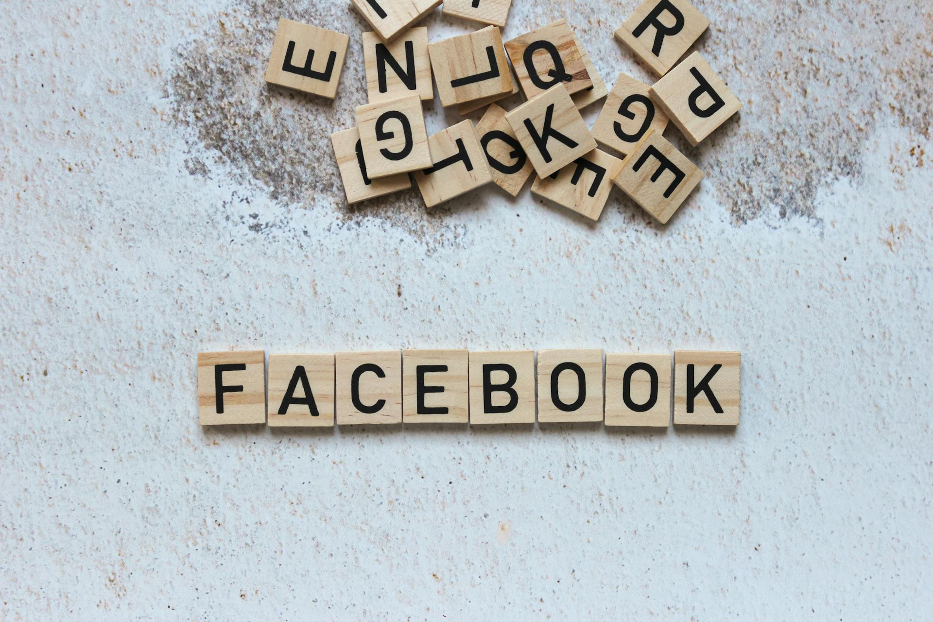 Wooden Scrabble tiles spelling Facebook on a textured surface. Ideal for social media concepts.