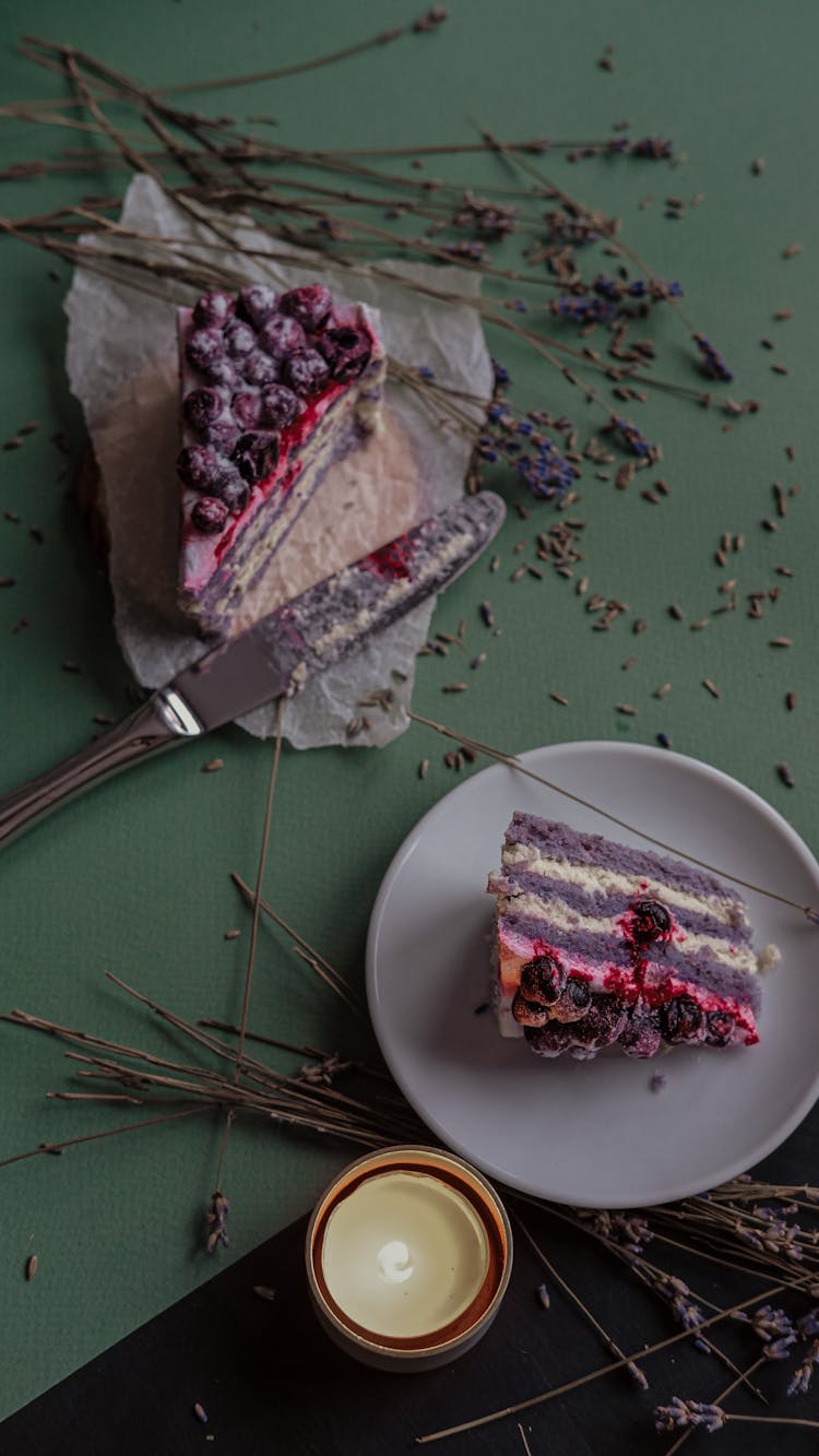 Food Presentation Of Sweet Desserts On Plates And Lit Scented Candle