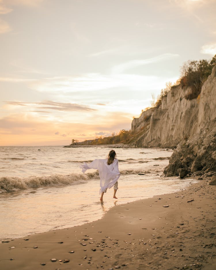 Woman Running On Beach At Sunset