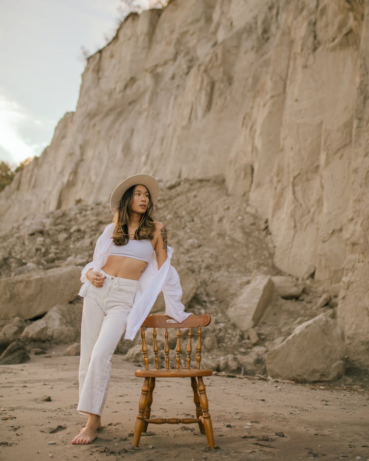 Woman Standing Leaning On Chair On Beach